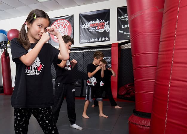 Kids practicing Krav Maga self-defense techniques at Krav Zone martial arts academy.